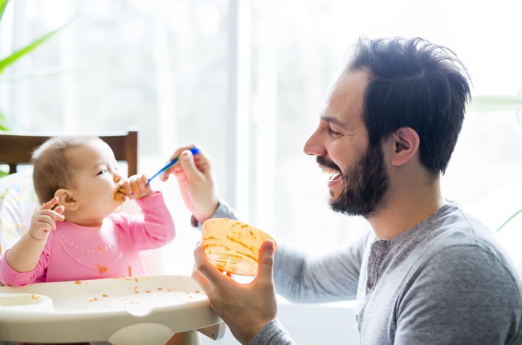 Father feeding daughter, primary custody is NOT just for moms.